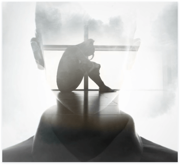 double exposure image of a head and a person sitting hugging their knees