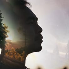 double exposure image of a head and a person sitting hugging their knees